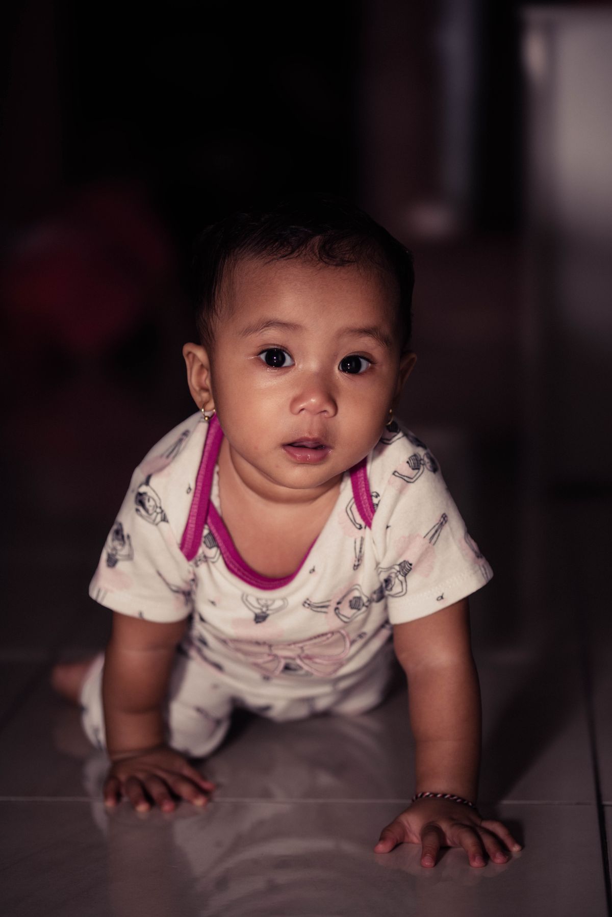 A baby crawling across the floor indoors