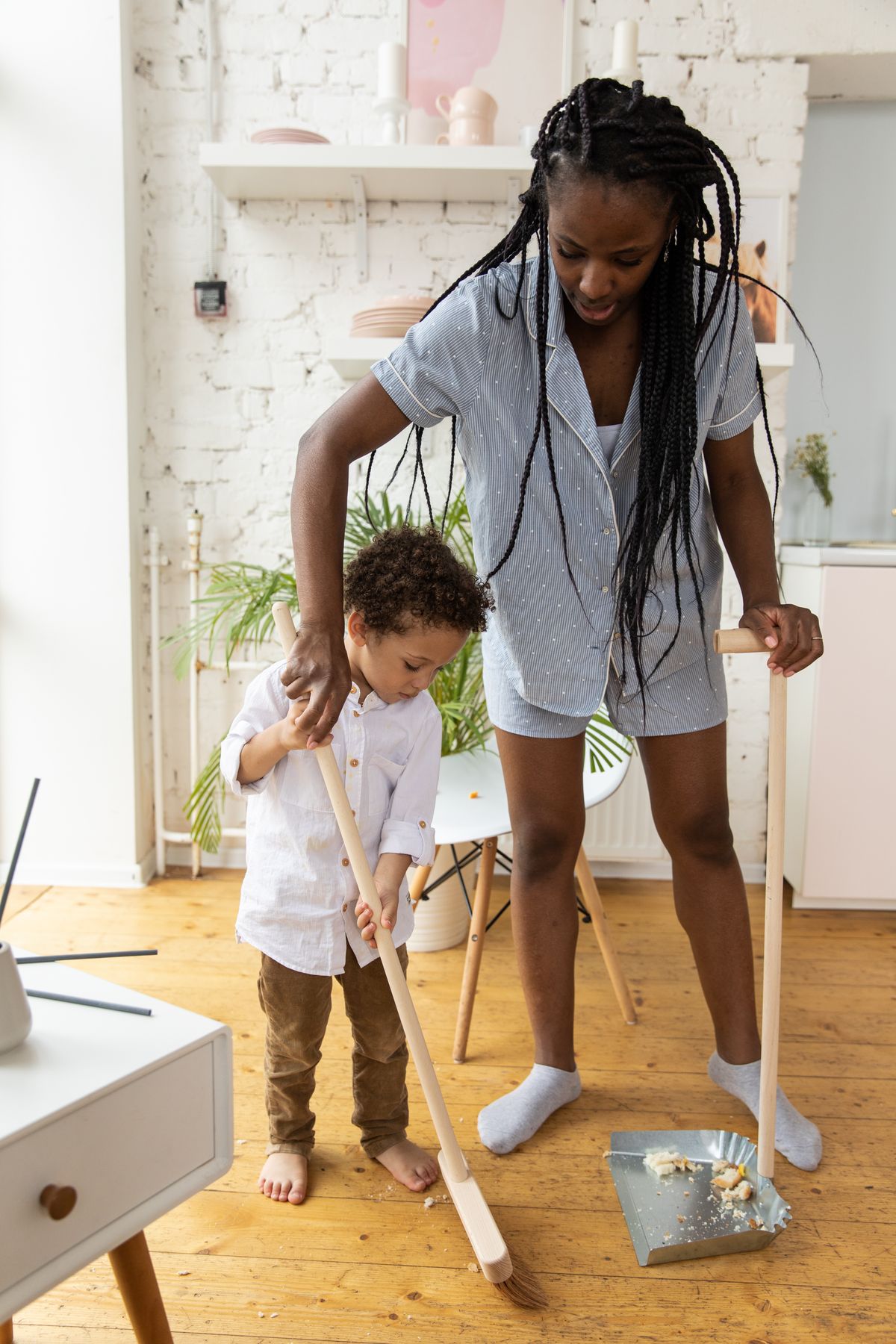 A child helping to sweep the floor at home