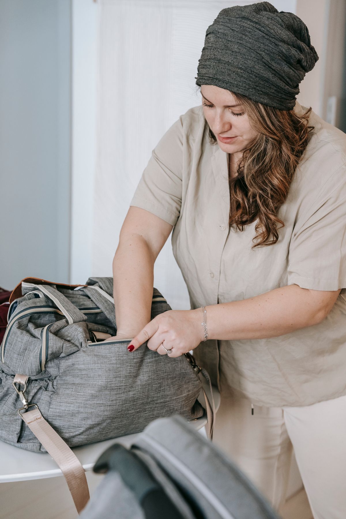 A parent packing a diaper bag before heading out with their baby