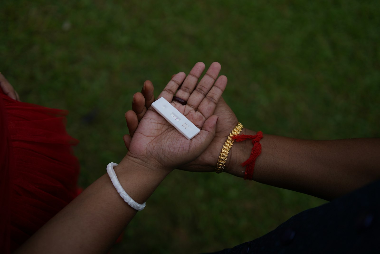 Two people holding a positive pregnancy test in their cupped hands