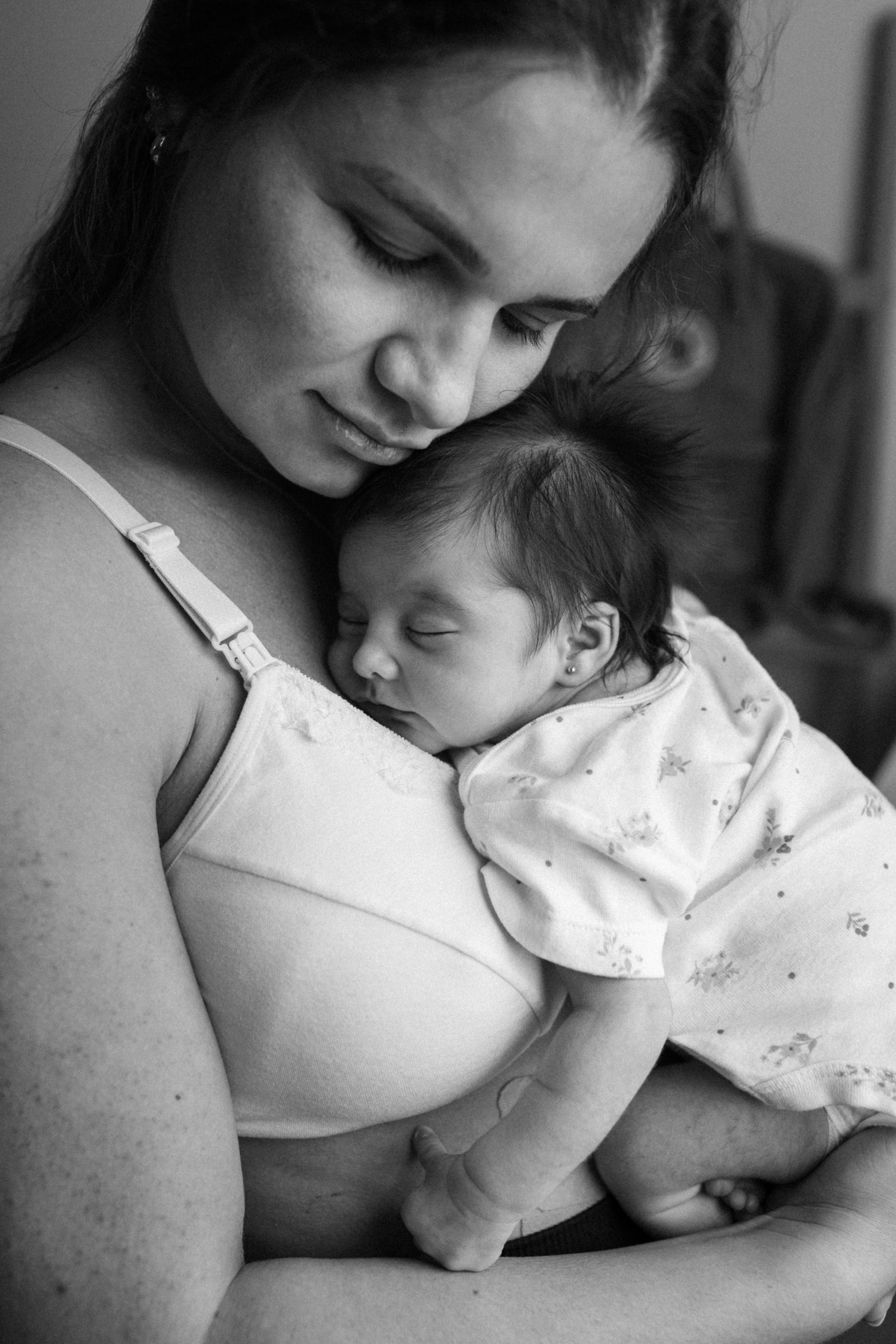 A woman gently holding her newborn baby