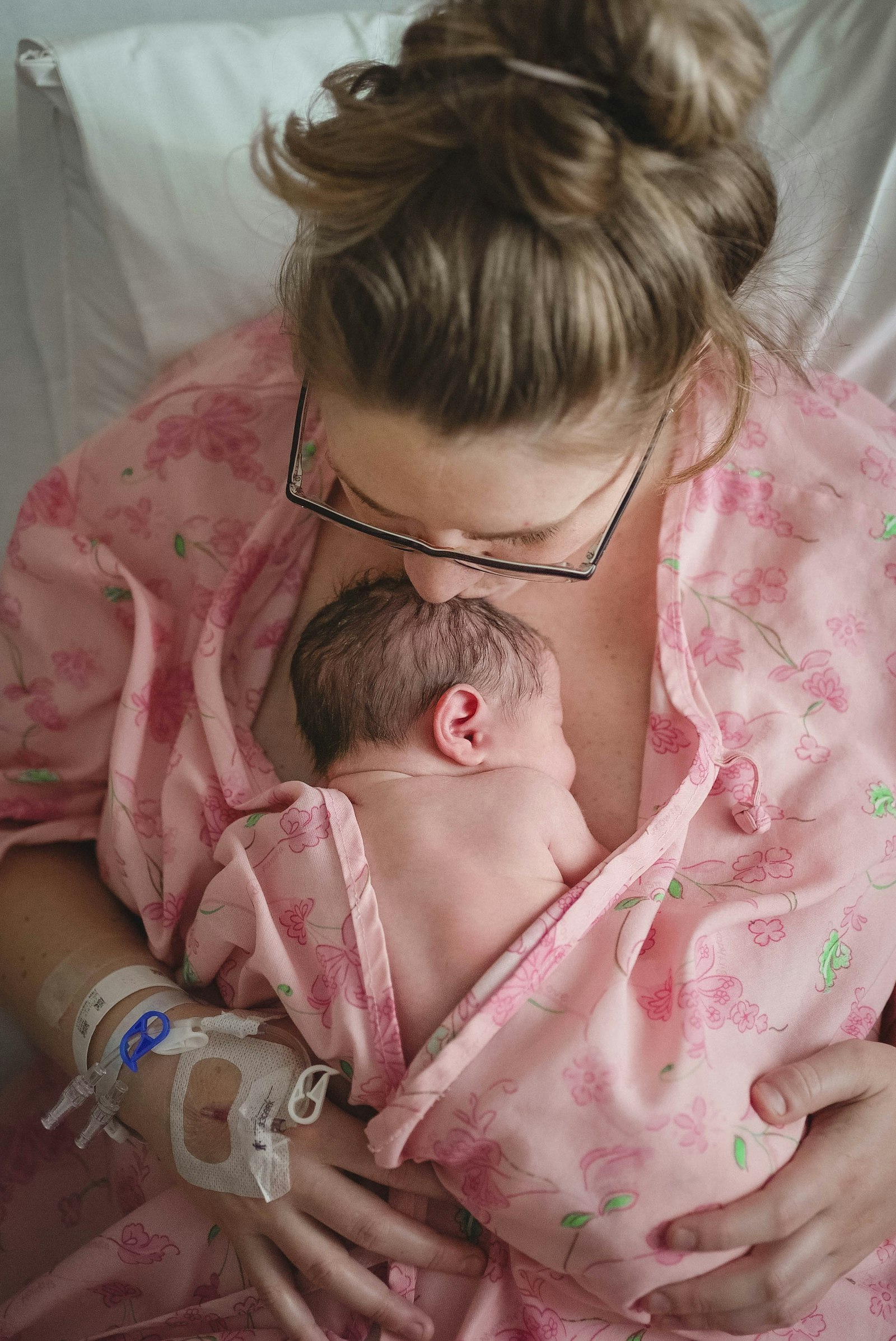 A woman in a robe holding her newborn baby