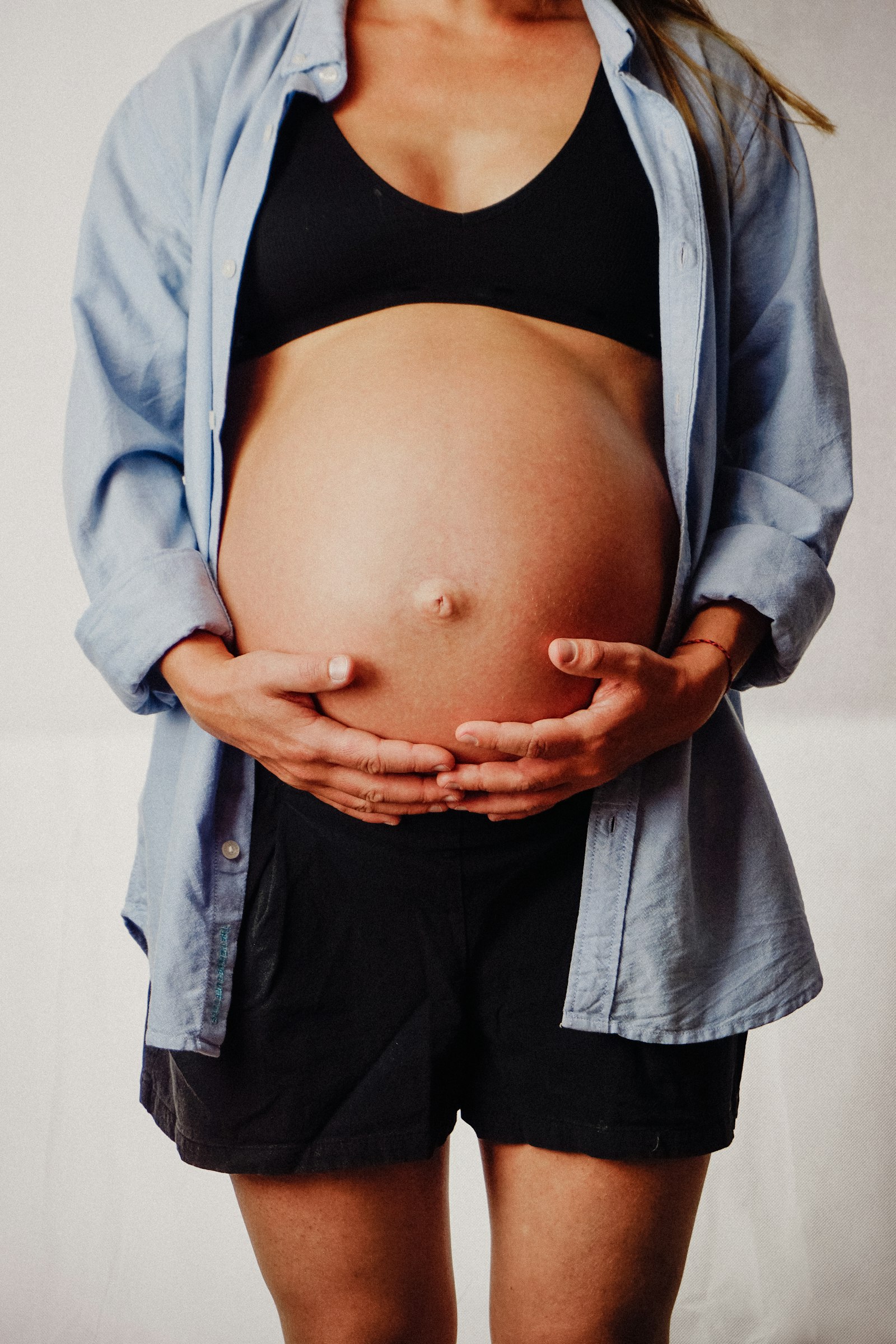A pregnant woman holding her belly in her hands