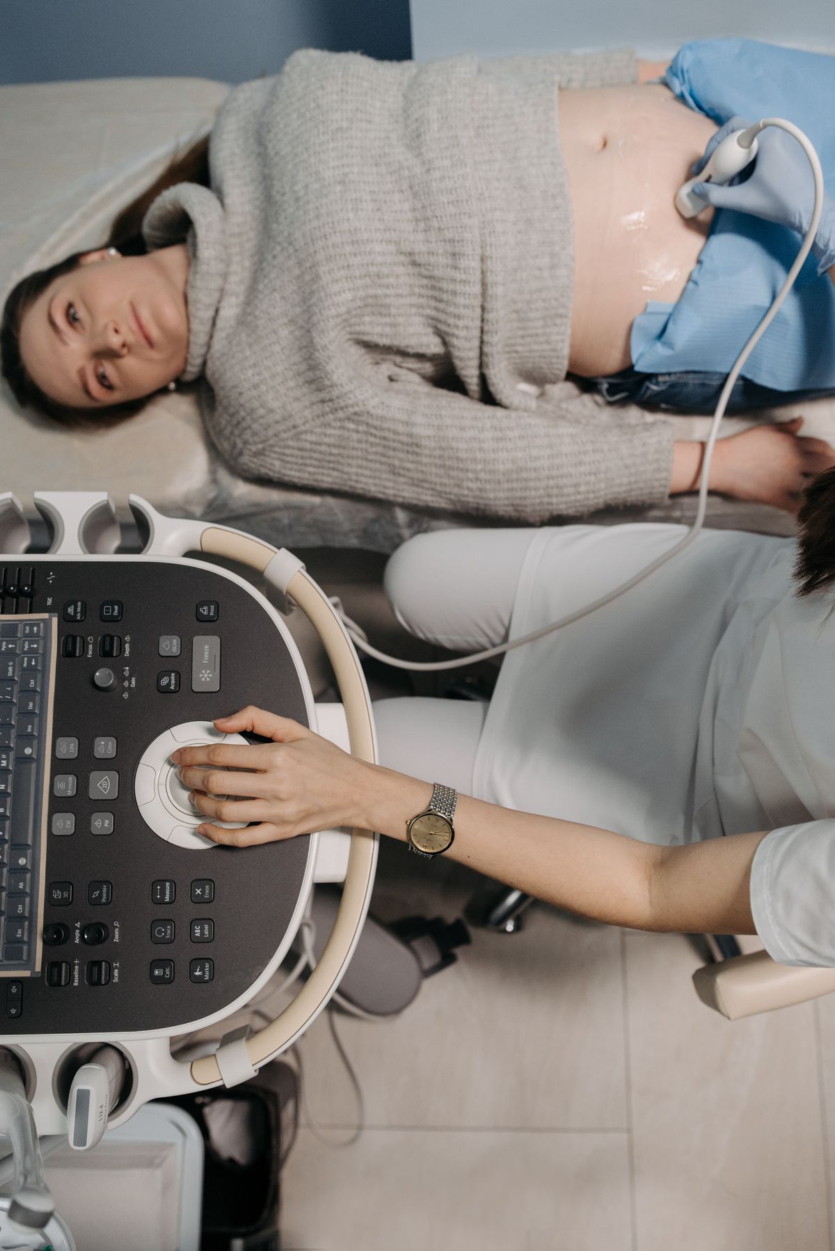 A doctor performing an ultrasound checkup on a pregnant patient