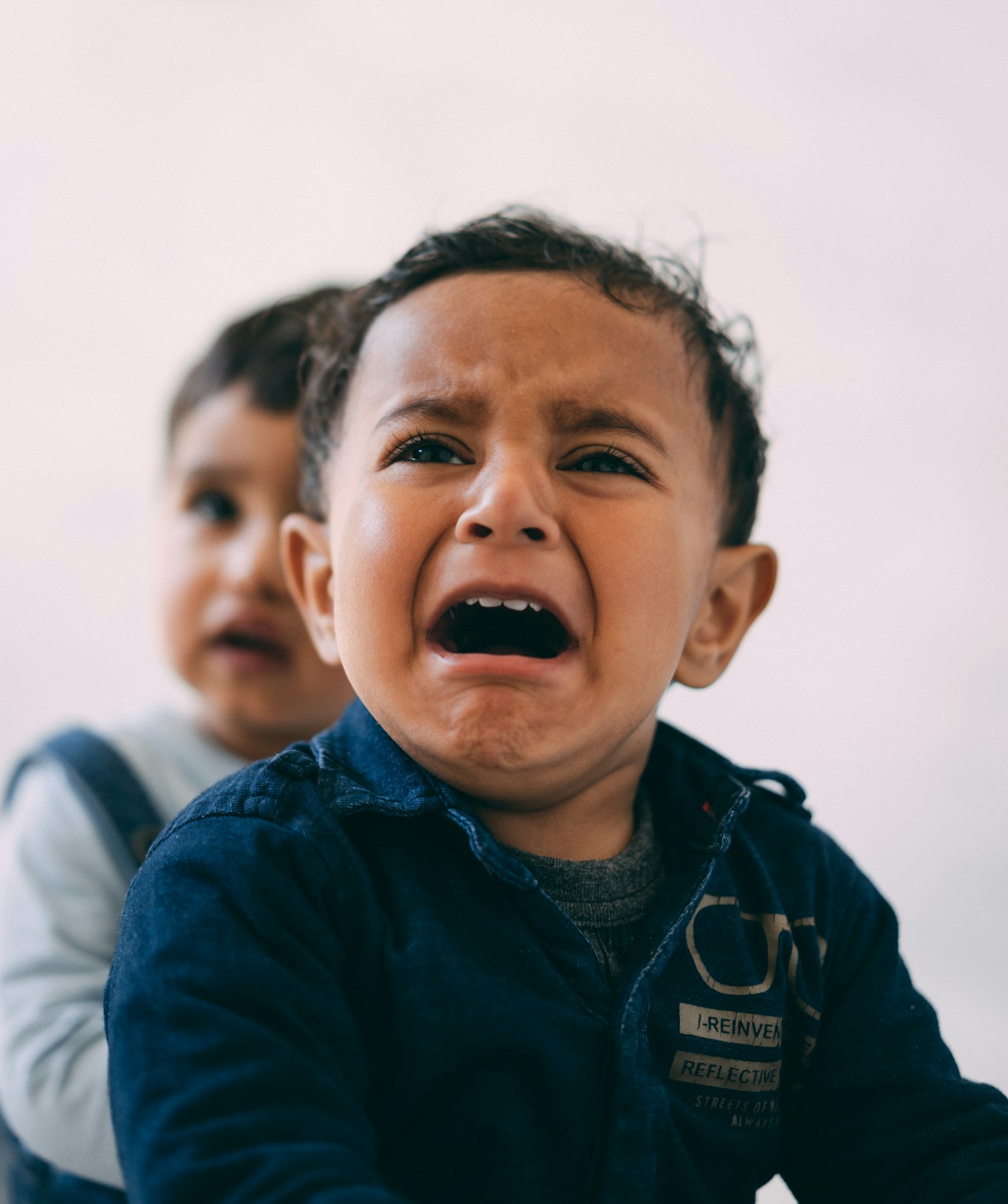 A toddler mid-meltdown with an open-mouthed cry