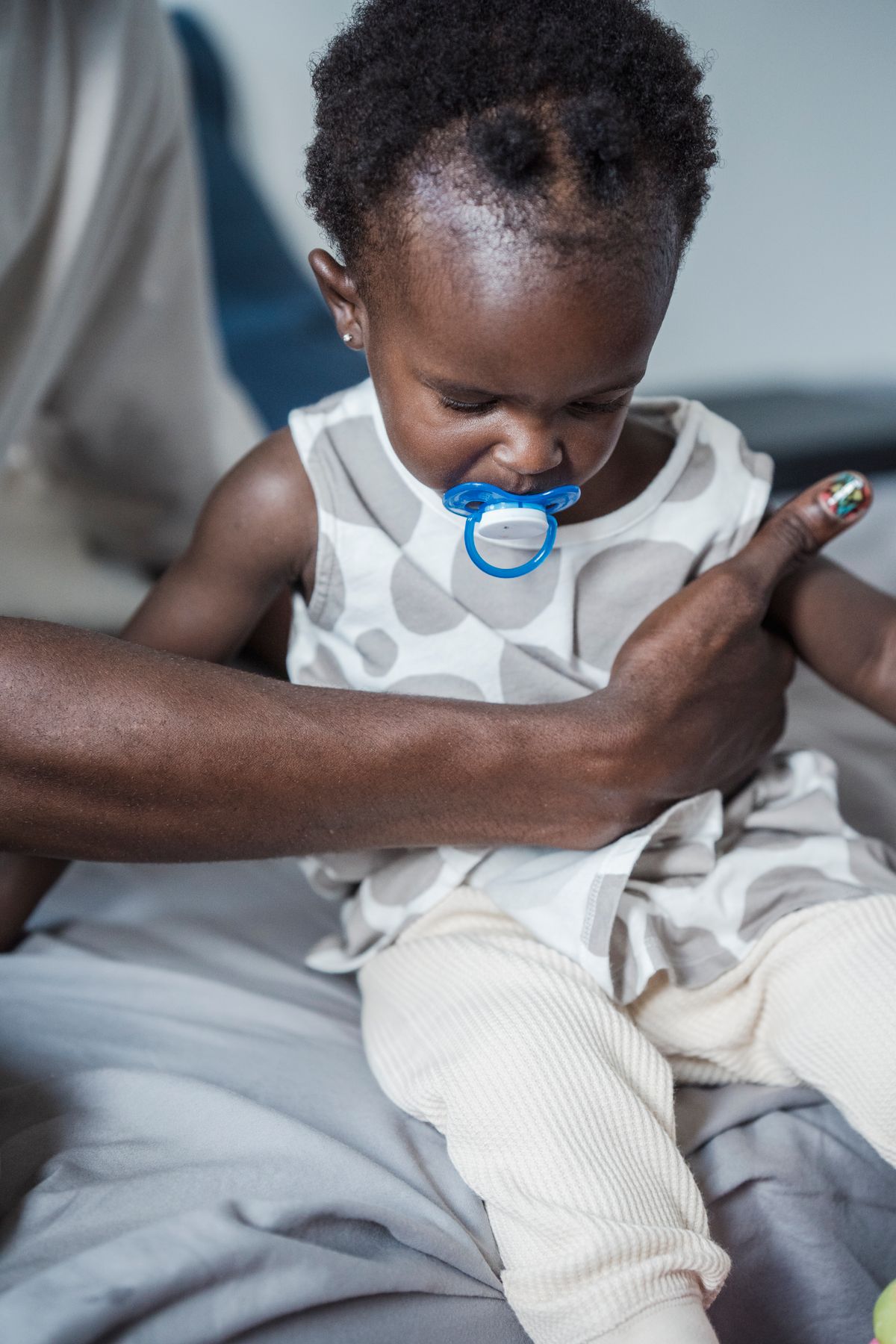 A toddler with a pacifier in their mouth