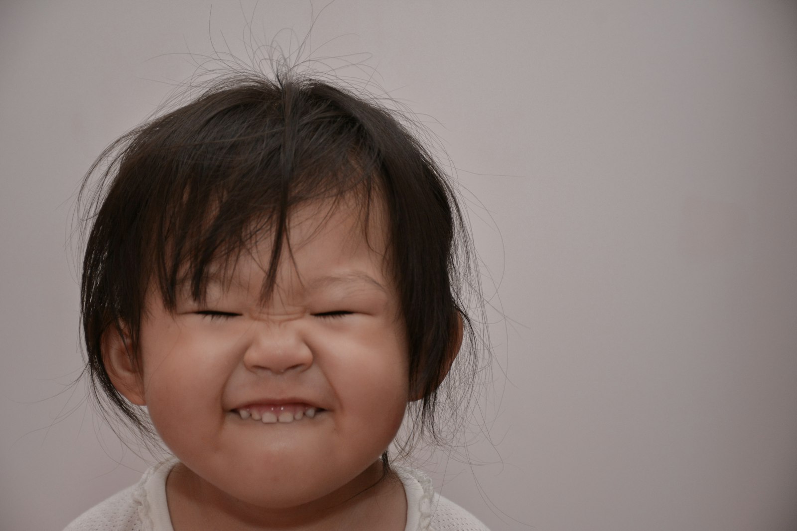 A young toddler with an upset expression